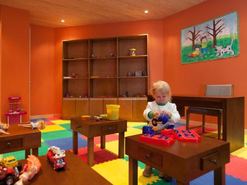 a little girl playing with toys in a room at Valle Corralco Hotel & Spa in Malalcahuello