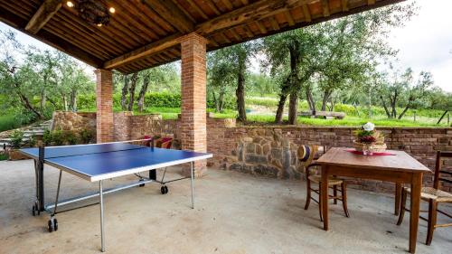 - une table de ping-pong sur une terrasse avec un mur en briques dans l'établissement DIMORA SAN GERMANO 14, Emma Villas, à San Miniato