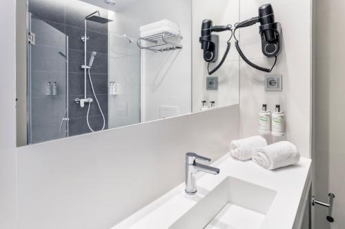 Un baño blanco con lavabo y ducha. en B&B HOTEL Murcia, en Murcia