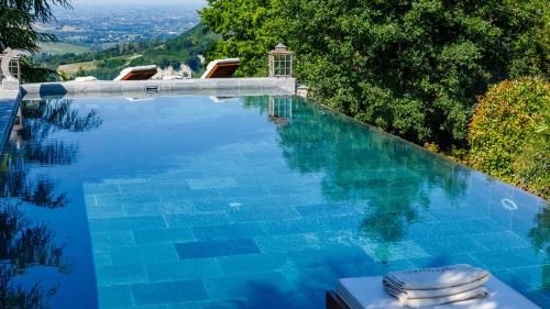 a swimming pool with blue water and some chairs at IL CASTELLACCIO 8, Emma Villas in Brisighella