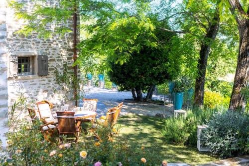 a garden with a table and chairs and trees at IL CASTELLACCIO 8, Emma Villas in Brisighella