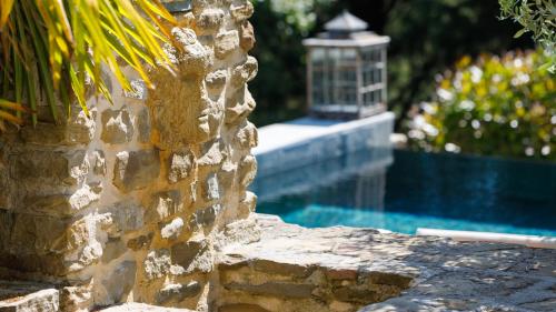 a stone wall next to a swimming pool at IL CASTELLACCIO 8, Emma Villas in Brisighella