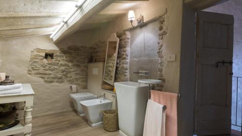 a bathroom with two toilets and a sink at IL CASTELLACCIO 8, Emma Villas in Brisighella