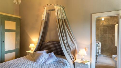 a bedroom with a canopy bed and a mirror at IL CASTELLACCIO 8, Emma Villas in Brisighella