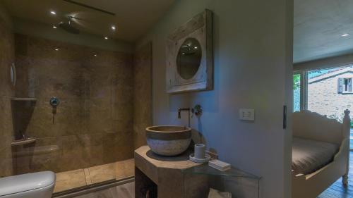 a bathroom with a shower and a bowl on a table at IL CASTELLACCIO 8, Emma Villas in Brisighella
