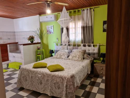 a bedroom with a large bed with green walls at La Villa Rosier in Le François
