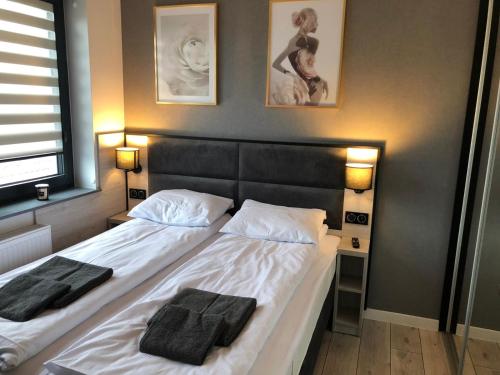 - une chambre avec un lit et 2 serviettes dans l'établissement Apartament Plaza Premium, à Słupca