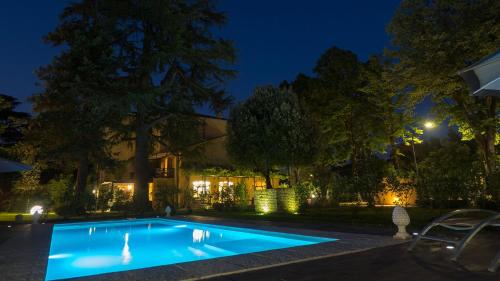 a swimming pool in front of a house at night at La Casa Di Nanì 8, Emma Villas in Forlì