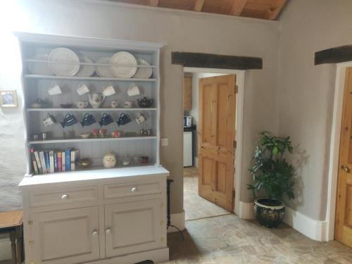 a kitchen with a shelf with plates on it at Glenkeel Cottage in Manorhamilton