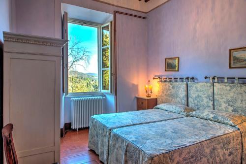 a bedroom with a bed and a large window at La Martinella 12, Emma Villas in Passignano sul Trasimeno