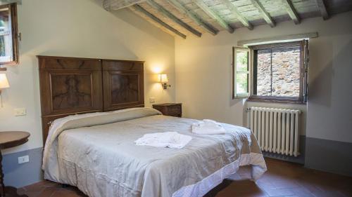 una camera da letto con un letto e due asciugamani di Le Caselle 26, Emma Villas a Cortona