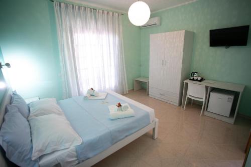 a bedroom with a bed and a desk and a television at B&B Leonida in Tropea