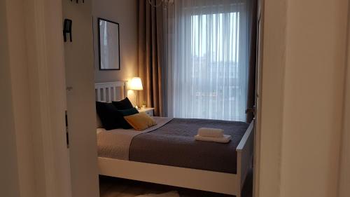 ein kleines Schlafzimmer mit einem Bett und einem Fenster in der Unterkunft Grochowska Apartment in Warschau