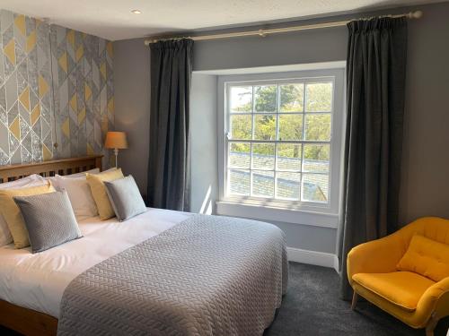 a bedroom with a bed and a window and a chair at St Agnes Hotel in St. Agnes 
