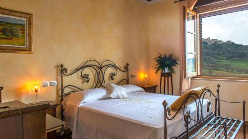 una camera da letto con un letto e un gatto seduto sopra di Le Terre Di Nunzio 12, Emma Villas a Montepulciano