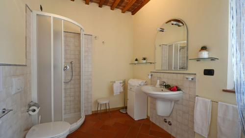 a bathroom with a sink and a toilet and a shower at L'Ovile 8, Emma Villas in Sovicille