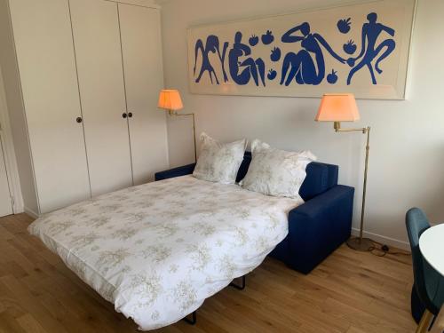 a bedroom with a bed with two lamps and a painting at Deauville Plage - Balcon, Vue Mer & Ville à pied in Deauville