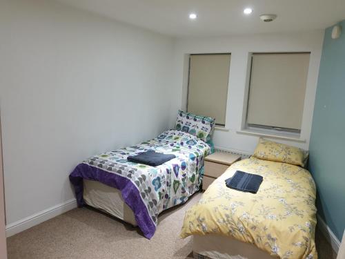 a bedroom with two beds and a window at Bramwell Court in Newcastle upon Tyne