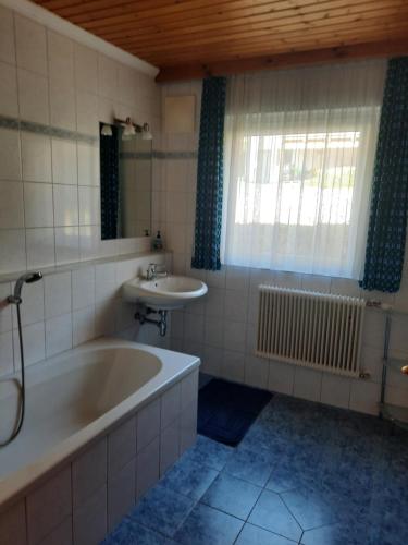 a bathroom with a tub and a sink at Grünwald Chalet in Maishofen