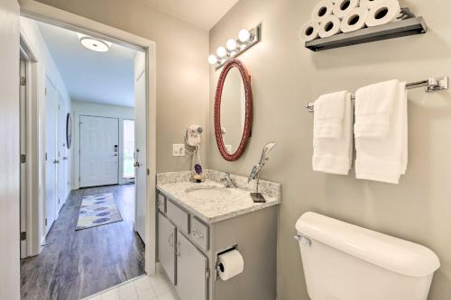 a bathroom with a sink and a toilet and a mirror at Interlaken Villa with Patio, Steps to Ridge Resort! in Lake Geneva
