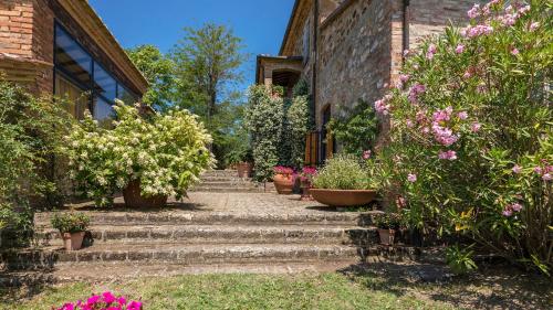 a set of stairs leading to a house with flowers at PODERINO 6, Emma Villas in Trequanda