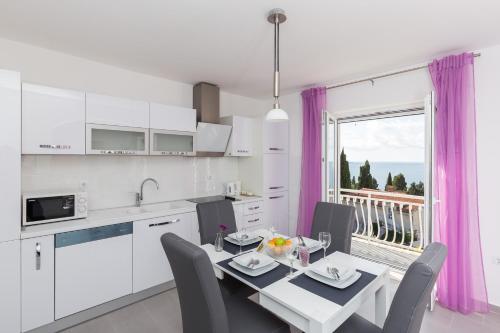 a kitchen and dining room with a table and chairs at Apartments Villa Enzian in Mlini