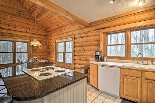 a kitchen in a log cabin with a stove at Secluded Gaylord Cabin with Deck, Fire Pit and Grill! in Gaylord