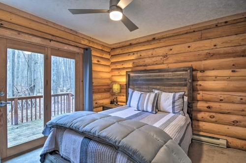 1 dormitorio con paredes de madera, 1 cama y ventana en Secluded Gaylord Cabin with Deck, Fire Pit and Grill!, en Gaylord