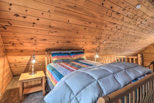 a bedroom with a bed in a log cabin at Secluded Gaylord Cabin with Deck, Fire Pit and Grill! in Gaylord