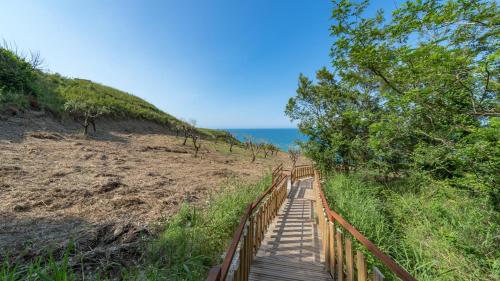 a wooden boardwalk leading down to the beach at RIPARI DI GIOBBE 6&2, Emma Villas in Ortona
