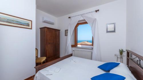 a bedroom with a bed and a window with the ocean at RIPARI DI GIOBBE 6&2, Emma Villas in Ortona
