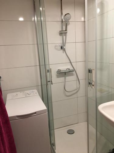 a shower with a glass door next to a sink at Les pins ensoleilles in Saint-Georges-de-Didonne