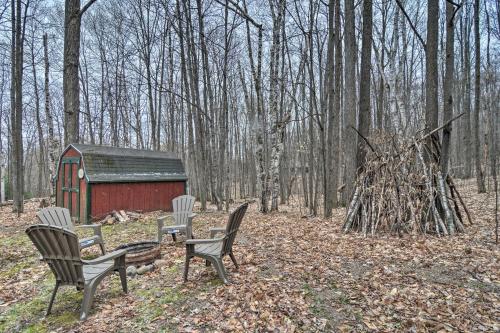 two chairs and a table and a red shed in the woods at Secluded Gaylord Cabin with Deck, Fire Pit and Grill! in Gaylord