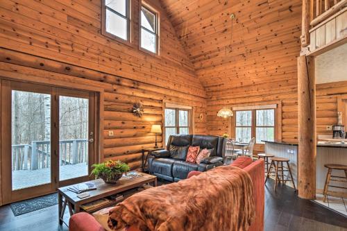 a living room with a couch and a table at Secluded Gaylord Cabin with Deck, Fire Pit and Grill! in Gaylord