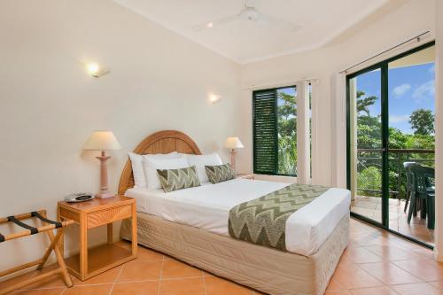 a bedroom with a bed and a balcony at Tropic Towers Apartments in Cairns