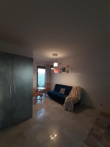a living room with a blue couch and a table at Apartamenty Róża Wiatrów in Solec-Zdrój
