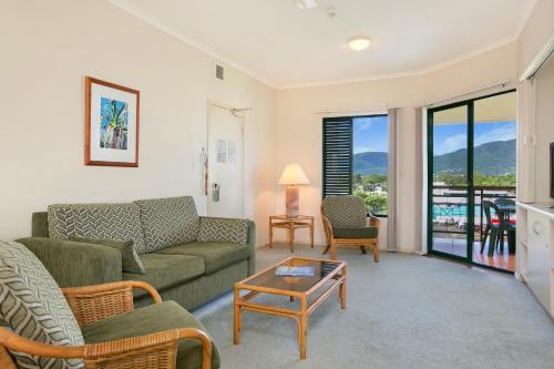 a living room with a couch and a table at Tropic Towers Apartments in Cairns