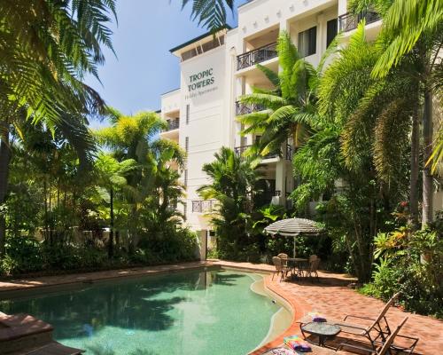 a swimming pool in front of a hotel at Tropic Towers Apartments in Cairns