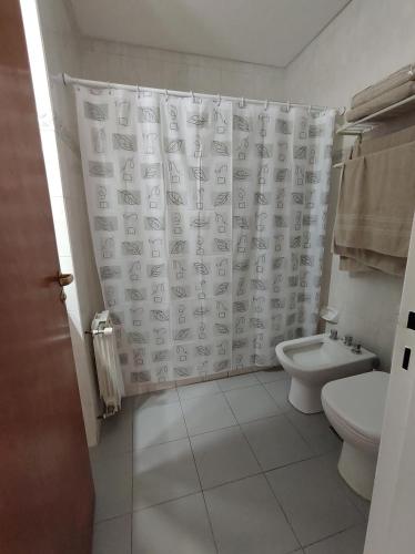 y baño con aseo y cortina de ducha. en DEPARTAMENTO EN MICROCENTRO CON COCHERA en Salta
