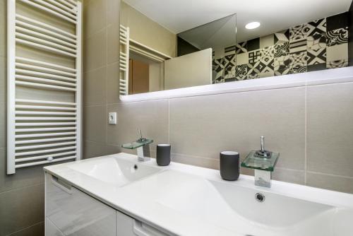 a bathroom with a white sink and a mirror at Maredimo Village Casa 3 in Porto