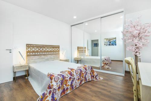 a bedroom with a large bed and a mirror at Maredimo Village Casa 3 in Porto