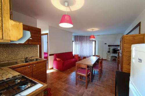 a kitchen with a table and a red couch at Casa Vacanze Belvedere in Castel di Sangro