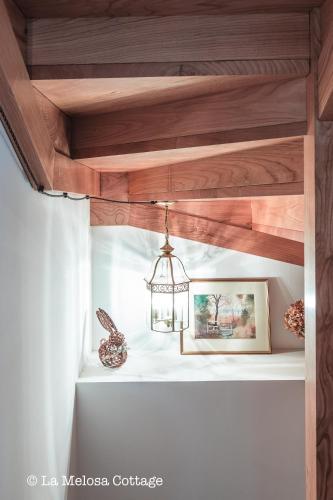 a chandelier hanging from a wooden ceiling at La Melosa Cottage in Cudillero