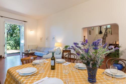 una sala de estar con una mesa con un jarrón de flores en Villa Dell'Angelo 10, Emma Villas en Rosignano Marittimo