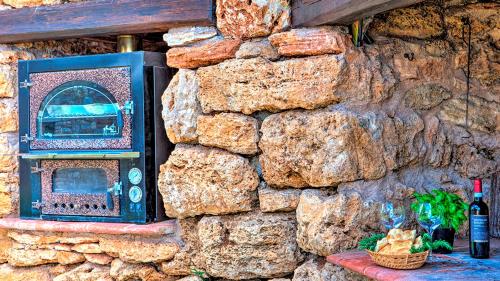 a stone wall with a toaster and a bottle of wine at Villa Bella 8, Emma Villas in Massa Martana