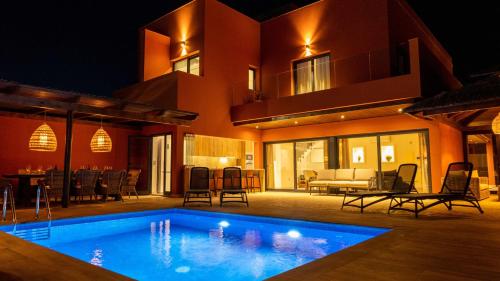una casa con piscina por la noche en Villa privada de lujo con piscina Villa Wabi Sabi, en Corralejo
