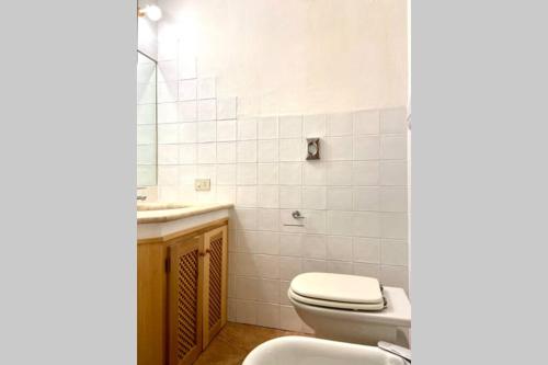 a bathroom with a toilet and a sink and a mirror at Sunrise 14 in San Pantaleo