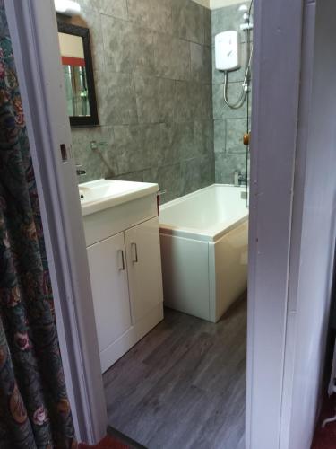 a bathroom with a sink and a tub and a toilet at Lile Cottage at Gleaston Water Mill in Ulverston