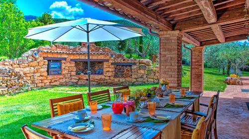a wooden table with an umbrella on a patio at Villa Bella 8, Emma Villas in Massa Martana