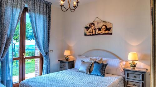 a bedroom with a bed with blue curtains and a window at Villa Bella 8, Emma Villas in Massa Martana